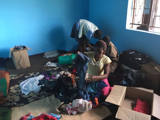 8 people live in this room, those are their freshly made "beds" on the floor and these clothes are all that they own. The items that are being sorted through, are what your donations bought at the market on Saturday.